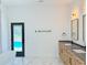 Modern bathroom features double vanities, a soaking tub and access to backyard pool at 1371 Melonie Trl, New Smyrna Beach, FL 32168