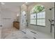 Elegant bathroom featuring marble floors, walk-in shower, and a large window for natural light at 1371 Melonie Trl, New Smyrna Beach, FL 32168