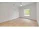 Minimalist bedroom with white walls, wood floors, window with outside view, and closet at 1371 Melonie Trl, New Smyrna Beach, FL 32168