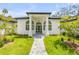 Stunning white stucco home with arched windows, black trim, and meticulously landscaped front yard at 1371 Melonie Trl, New Smyrna Beach, FL 32168