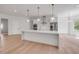 New kitchen featuring an island, stainless appliances, white cabinets, pendant lights, and wood floors at 1371 Melonie Trl, New Smyrna Beach, FL 32168