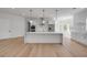 New kitchen featuring an island, stainless appliances, white cabinets, pendant lights, and wood floors at 1371 Melonie Trl, New Smyrna Beach, FL 32168