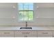 Modern kitchen featuring white cabinets, quartz countertops, floating shelves, and a garden view at 1371 Melonie Trl, New Smyrna Beach, FL 32168