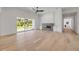 Bright living room featuring hardwood floors, fireplace, and a large glass sliding door to the backyard at 1371 Melonie Trl, New Smyrna Beach, FL 32168