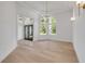 Bright living room with wood floors, arched windows, a modern chandelier, and double front doors at 1371 Melonie Trl, New Smyrna Beach, FL 32168