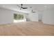 Open living room with hardwood floors, ceiling fans, and a view of the pool at 1371 Melonie Trl, New Smyrna Beach, FL 32168