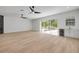 Open living room with hardwood floors, ceiling fans, and a sliding glass door at 1371 Melonie Trl, New Smyrna Beach, FL 32168