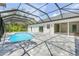 Backyard view of the sparkling pool, patio, and screened enclosure of this pristine Florida home at 1371 Melonie Trl, New Smyrna Beach, FL 32168