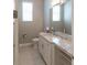 Bathroom features a vanity with granite countertops, a large mirror, and tile flooring at 1787 Earhart Ct, Port Orange, FL 32128
