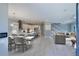 Open-concept living room features a dining area, kitchen, and a staircase with a comfortable gray sofa at 1787 Earhart Ct, Port Orange, FL 32128