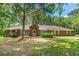 Charming brick single-story home with a well-manicured lawn and mature trees providing ample shade at 32030 Dewberry Ln, Sorrento, FL 32776