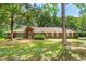 Well-maintained brick home with a lush green lawn and mature trees at 32030 Dewberry Ln, Sorrento, FL 32776