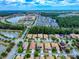 Aerial shot featuring residential neighborhood with a lake, community buildings, and tree-lined streets at 3455 Pegaso Ave, New Smyrna Beach, FL 32168