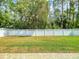 A spacious, green backyard featuring a white fence for privacy and a brick-paved patio area at 3455 Pegaso Ave, New Smyrna Beach, FL 32168