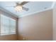 A bright bedroom features a ceiling fan and a large window with blinds at 3455 Pegaso Ave, New Smyrna Beach, FL 32168