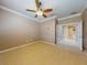 Large bedroom with carpet, crown molding, ceiling fan, and french doors leading to bathroom at 3455 Pegaso Ave, New Smyrna Beach, FL 32168