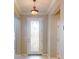 Close up of the entry with a decorative glass door, and a hanging light fixture at 3455 Pegaso Ave, New Smyrna Beach, FL 32168