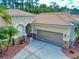 View of home's facade showcasing garage and well-kept landscaping at 3455 Pegaso Ave, New Smyrna Beach, FL 32168