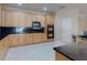 Bright kitchen featuring wooden cabinetry, black countertops, and stainless steel appliances at 3455 Pegaso Ave, New Smyrna Beach, FL 32168