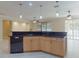 Kitchen with black countertops and wood cabinets adjacent to a living area and sliding glass doors at 3455 Pegaso Ave, New Smyrna Beach, FL 32168