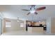 Spacious living area featuring tile floors, ceiling fans, and an adjacent kitchen with modern appliances at 3455 Pegaso Ave, New Smyrna Beach, FL 32168