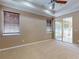 Main bedroom featuring a tray ceiling, fan, and access to the lanai via sliding doors at 3455 Pegaso Ave, New Smyrna Beach, FL 32168