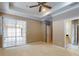 Main bedroom with carpet, fan, tray ceiling, walk-in closet, and access to a sunroom at 3455 Pegaso Ave, New Smyrna Beach, FL 32168