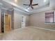 Spacious main bedroom with carpet, fan, tray ceiling, and ensuite entrance at 3455 Pegaso Ave, New Smyrna Beach, FL 32168