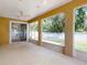 Screened lanai features a ceiling fan, screen windows, and backyard view at 3455 Pegaso Ave, New Smyrna Beach, FL 32168
