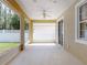Covered back patio with white ceiling fan and vinyl-screened enclosure at 3455 Pegaso Ave, New Smyrna Beach, FL 32168