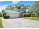 Traditional two-story home with stone accents, attached garage, and a spacious driveway on a sunny day at 3644 Dame St, Port Orange, FL 32129