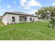 Spacious backyard with green grass, and a view of the back of the house at 377 Palm Dr, New Smyrna Beach, FL 32168