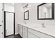 Well-lit bathroom featuring double sinks, white cabinets, and a large framed mirror at 377 Palm Dr, New Smyrna Beach, FL 32168