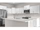 Modern kitchen featuring white cabinets, stainless steel appliances, and a spacious center island at 377 Palm Dr, New Smyrna Beach, FL 32168