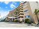 Lovely condominium building with lush landscaping, palm trees, and covered entrance at 4651 S Atlantic Ave # 7060, Port Orange, FL 32127