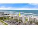 Inviting condominium building with ocean views, lush greenery, and a well-kept parking area at 5201 S Atlantic Ave # 708A, New Smyrna Beach, FL 32169