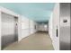 Hallway leading to the entrance door featuring elevator, railing and wall decor at 5201 S Atlantic Ave # 708A, New Smyrna Beach, FL 32169