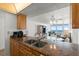 Open-concept kitchen with stone countertops and stainless steel sink featuring ocean view and white appliances at 5201 S Atlantic Ave # 708A, New Smyrna Beach, FL 32169