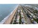Expansive aerial view of oceanfront community and nearby estuary featuring a long stretch of pristine beach at 6260 S Atlantic Ave, New Smyrna Beach, FL 32169