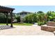 Backyard featuring a stone-paved patio, fire pit, and lush landscaping at 6260 S Atlantic Ave, New Smyrna Beach, FL 32169