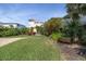 Lush backyard with green lawn, vibrant landscaping, and glimpses of the surrounding neighborhood at 6260 S Atlantic Ave, New Smyrna Beach, FL 32169