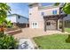 Large backyard with a stone-paved patio, pergola, and a grassy area at 6260 S Atlantic Ave, New Smyrna Beach, FL 32169