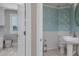Nautical themed half-bath featuring a pedestal sink and an adjacent laundry room at 6260 S Atlantic Ave, New Smyrna Beach, FL 32169