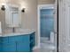 Bathroom with a blue vanity, decorative mirror, and an accessible walk-in shower at 6260 S Atlantic Ave, New Smyrna Beach, FL 32169