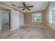 Comfortable bedroom with a ceiling fan, tile flooring, and bright natural light from the shuttered windows at 6260 S Atlantic Ave, New Smyrna Beach, FL 32169