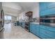 Bright and airy kitchen featuring blue cabinets, stainless steel appliances, and a backsplash with stylish tile design at 6260 S Atlantic Ave, New Smyrna Beach, FL 32169