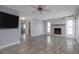 A living room with a fireplace, a flatscreen tv, shutters, and tile flooring at 6260 S Atlantic Ave, New Smyrna Beach, FL 32169