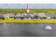 A row of houses with screened pools situated on a grassy green lawn and a lake at 6277 W Fallsgrove Ln, Port Orange, FL 32128