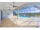 Open-air lanai with travertine tile overlooking a screened pool and lake at 6277 W Fallsgrove Ln, Port Orange, FL 32128