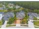 An aerial view shows a home with lush landscaping, a brick driveway, and a tranquil pond, nestled in a quiet neighborhood at 6950 Vintage Ln, Port Orange, FL 32128
